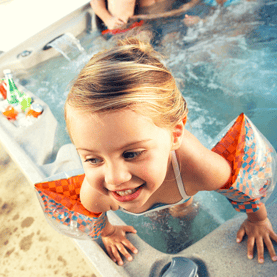 little girl in floaties in hot tub