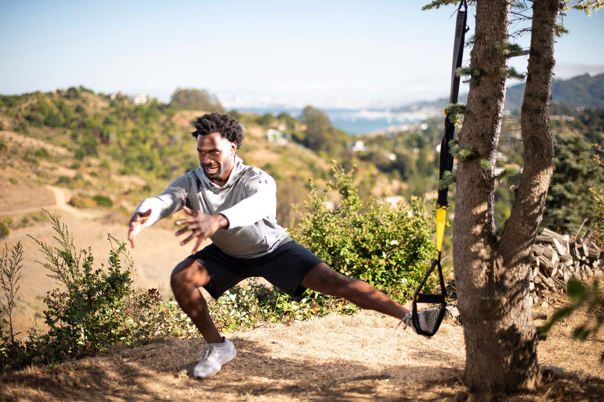 man doing side lunge outdoors on TRX Suspension Trainer