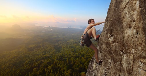 Uomo si arrampica su una parete rocciosa_ concetto di rischio
