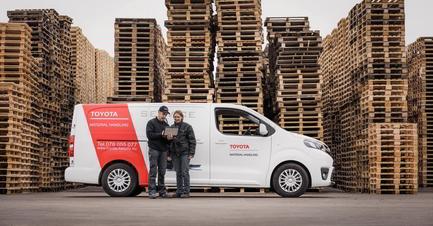 Servicetechniker bei Beratung von Kundin vor Van