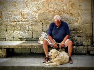 older man outdoors with pet dog