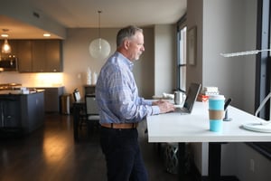 man working at home at standing desk with laptop