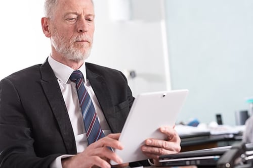 Man in suit viewing tablet