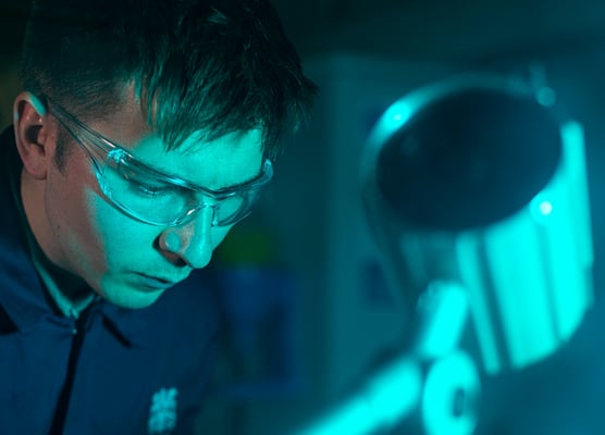 Must-have modern workplace tools to secure your organisation from data loss - man wearing goggles working in a blue-lit environment