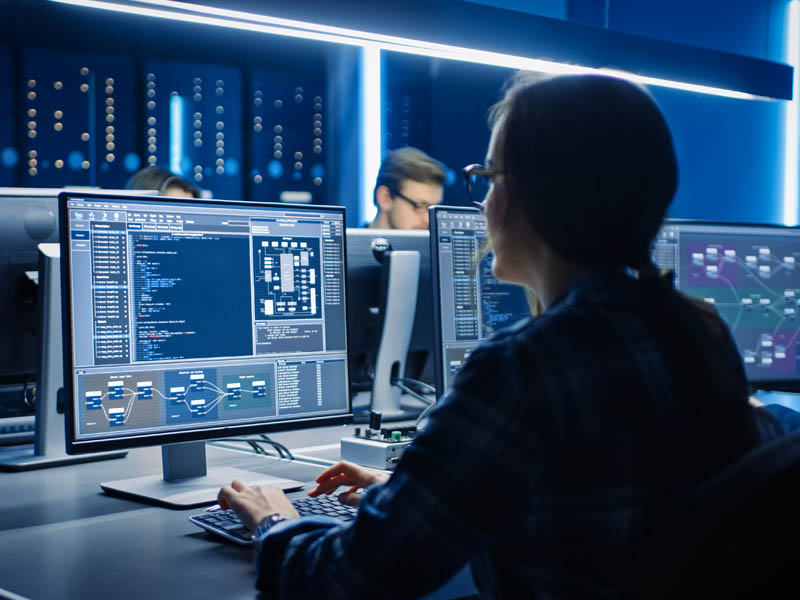 Mujer programadora IT trabajando en computadora de escritorio 