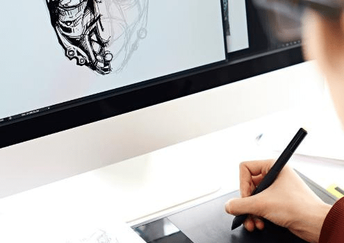 Photographie d'une personne dessinant sur un ordinateur