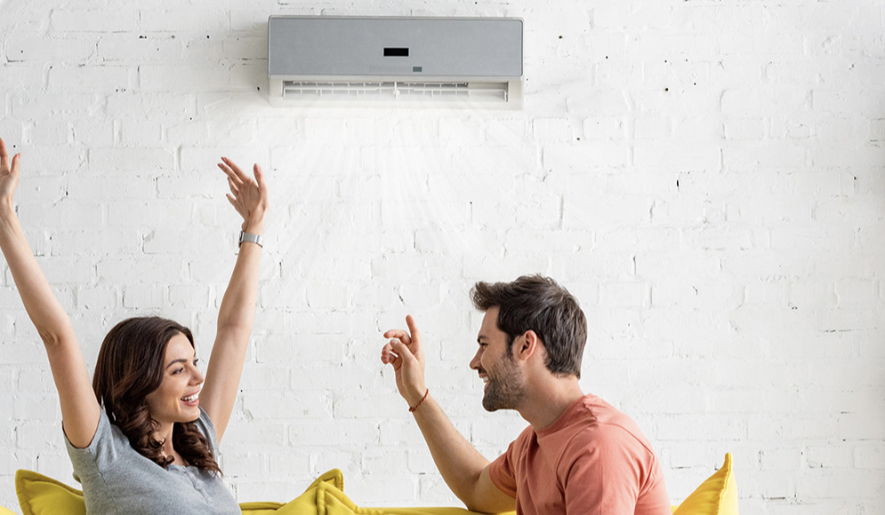 Couple sitting in front of a AC