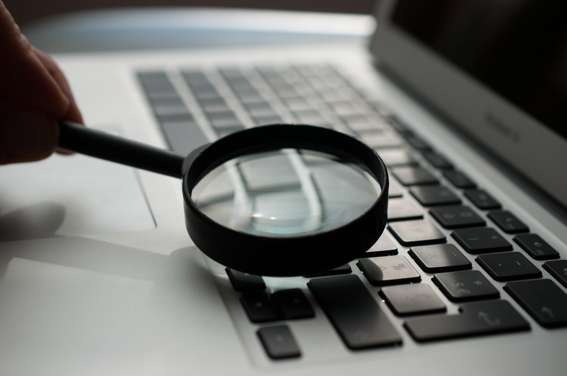 Black magnifying glass on laptop