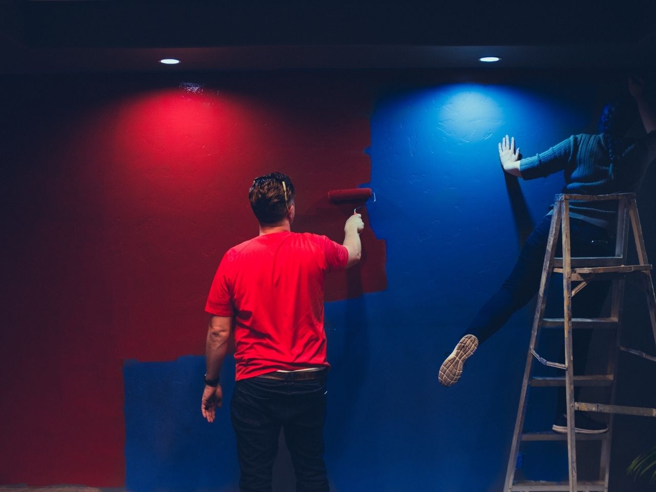 Man and woman painting a wall