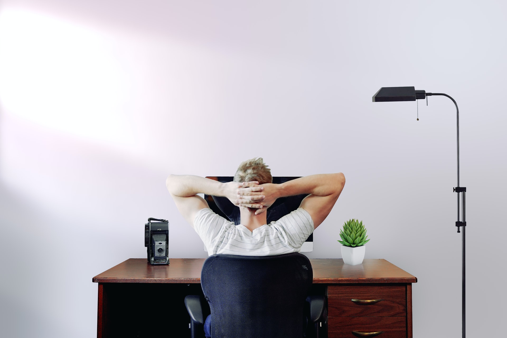 Man holding his head while sitting on a chair