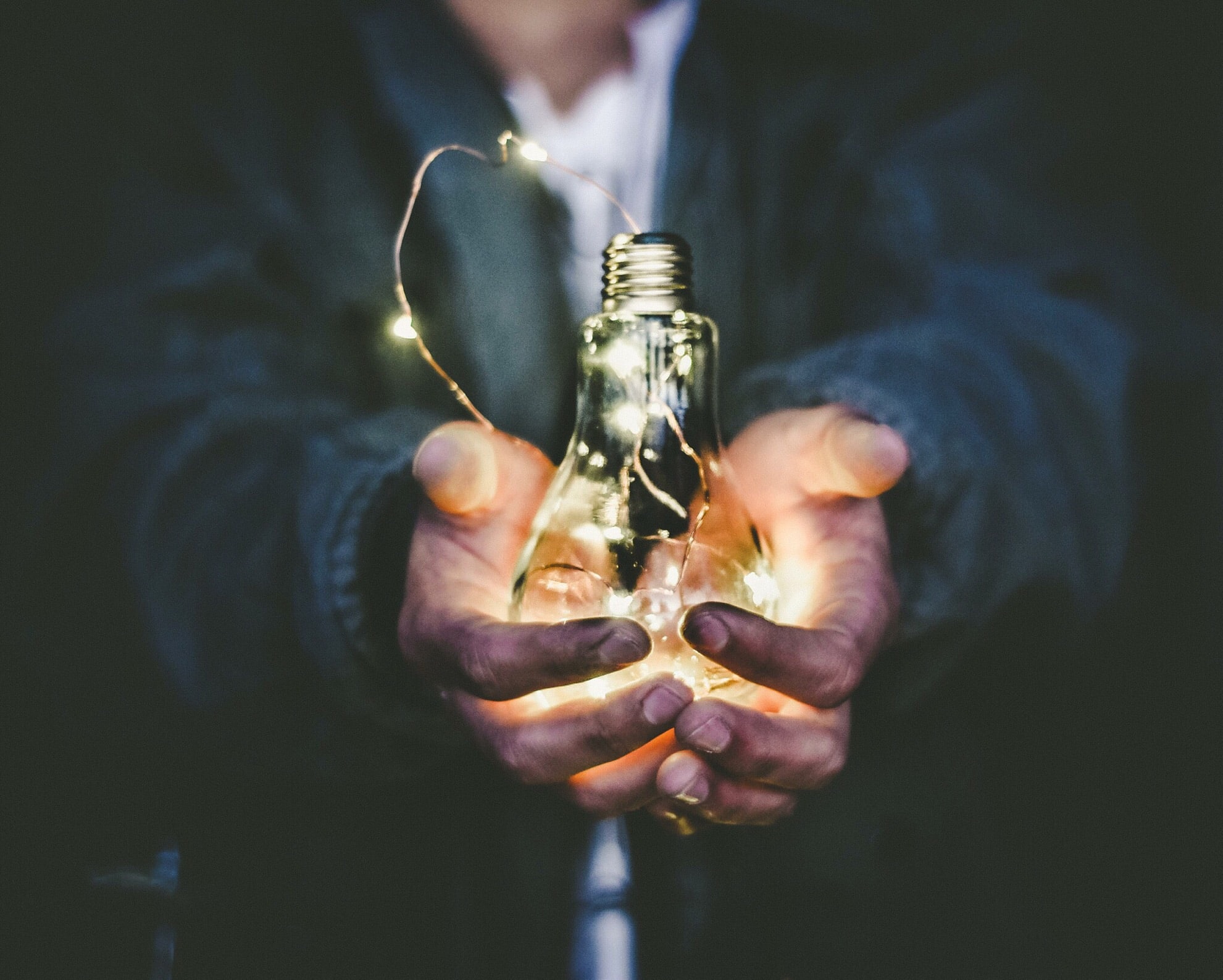 Man holding lightbulb before him