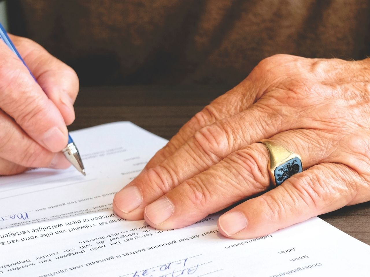 Old man signing a paper