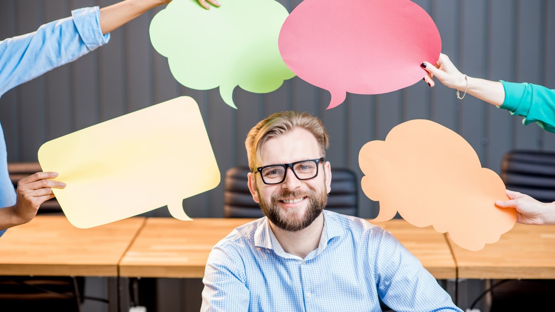 Man smiling surrounded by speech bubbles