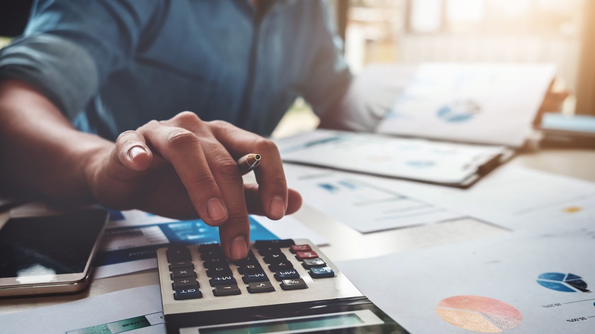 Man using calculator on desk