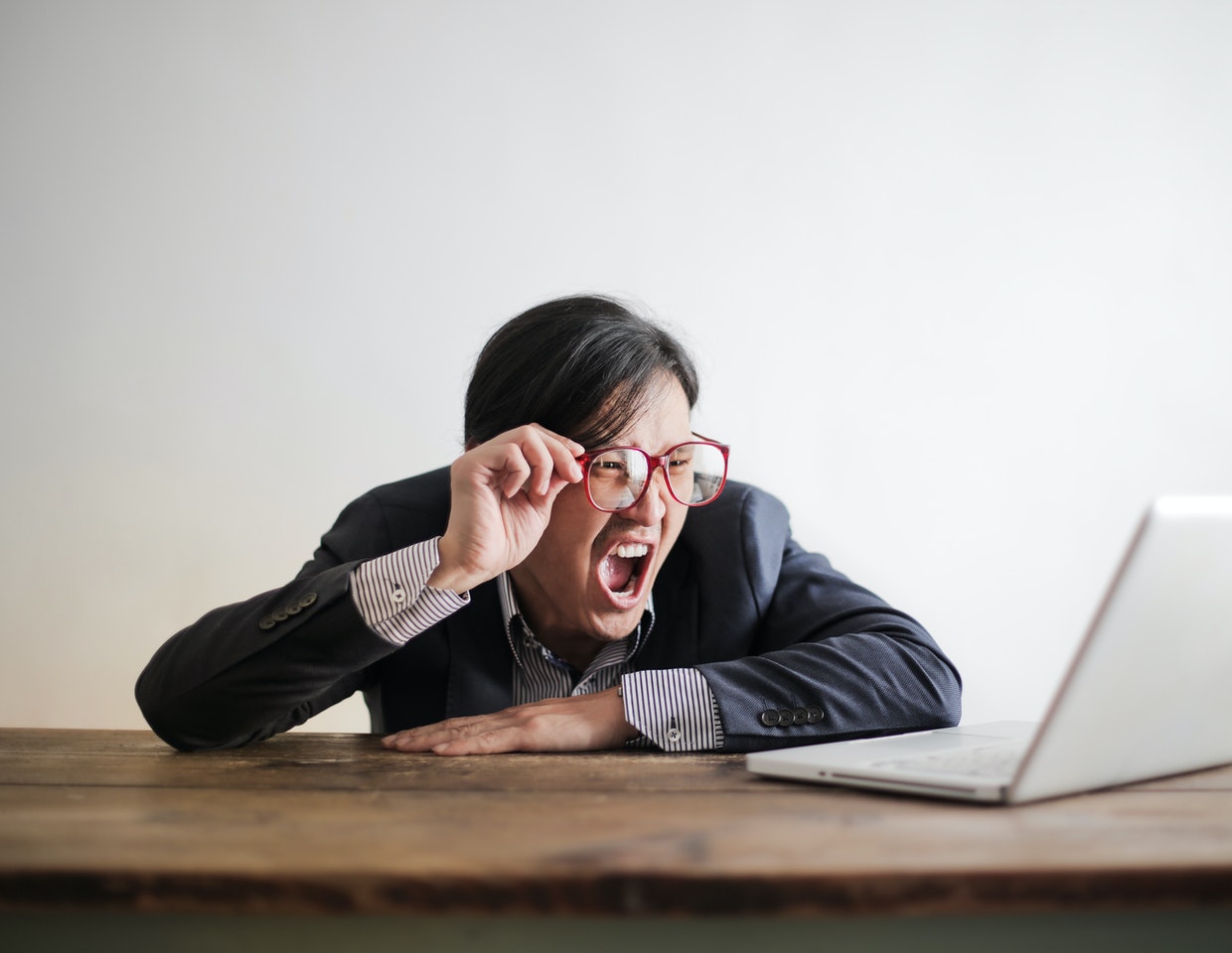 Man yelling at a grey laptop