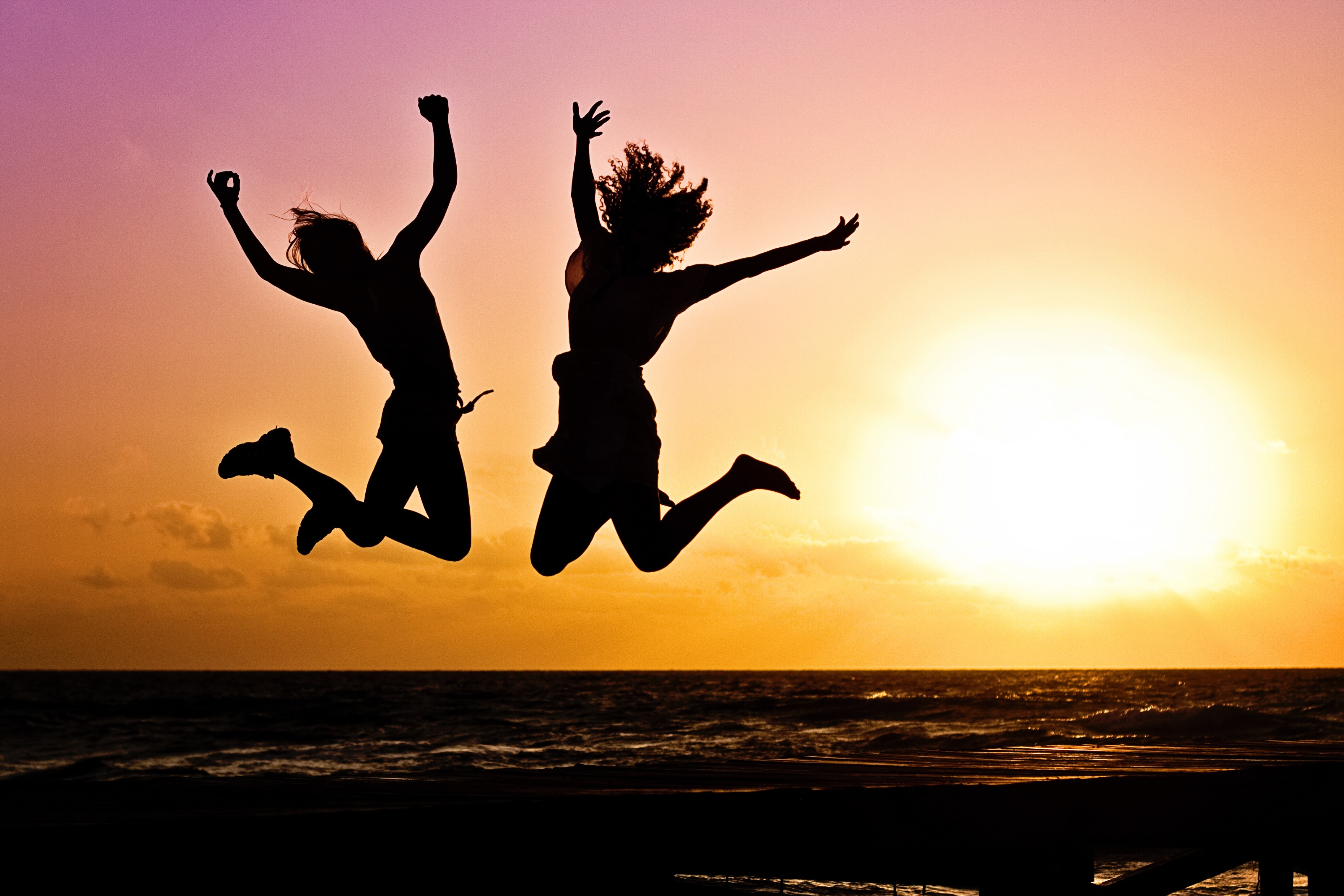 People jumping for joy in the sunset