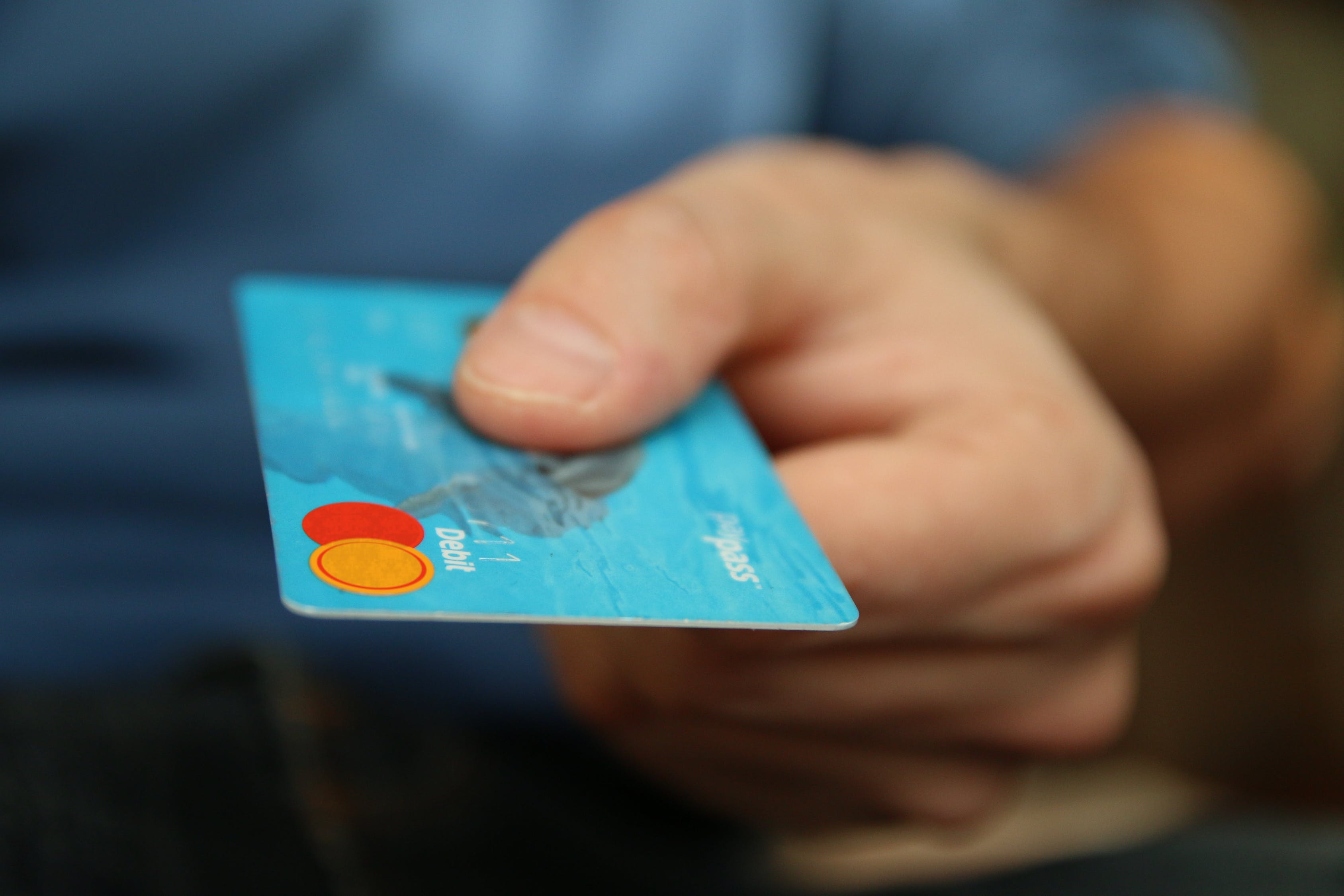 Person handing blue credi card