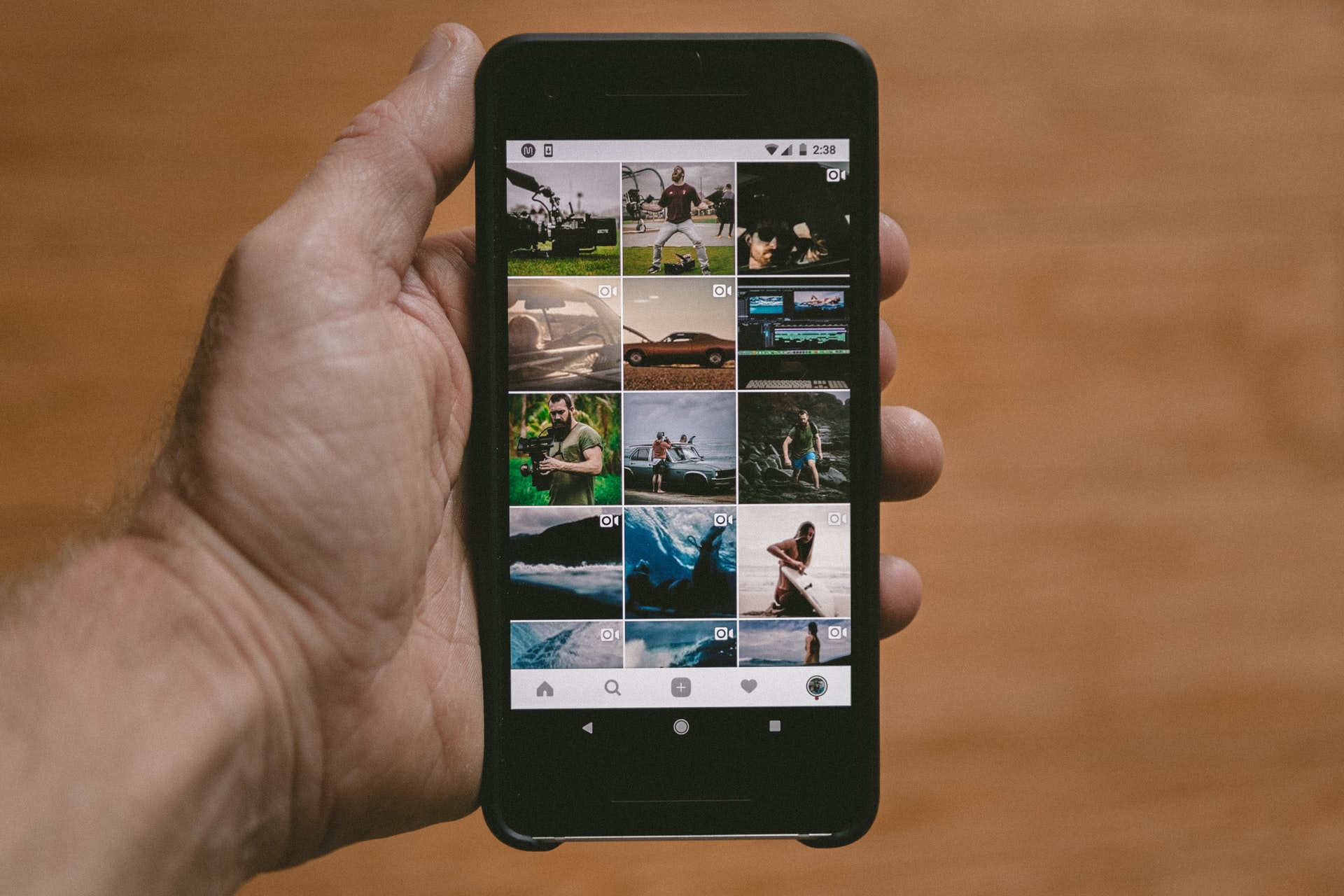 Person holding black mobile with photos