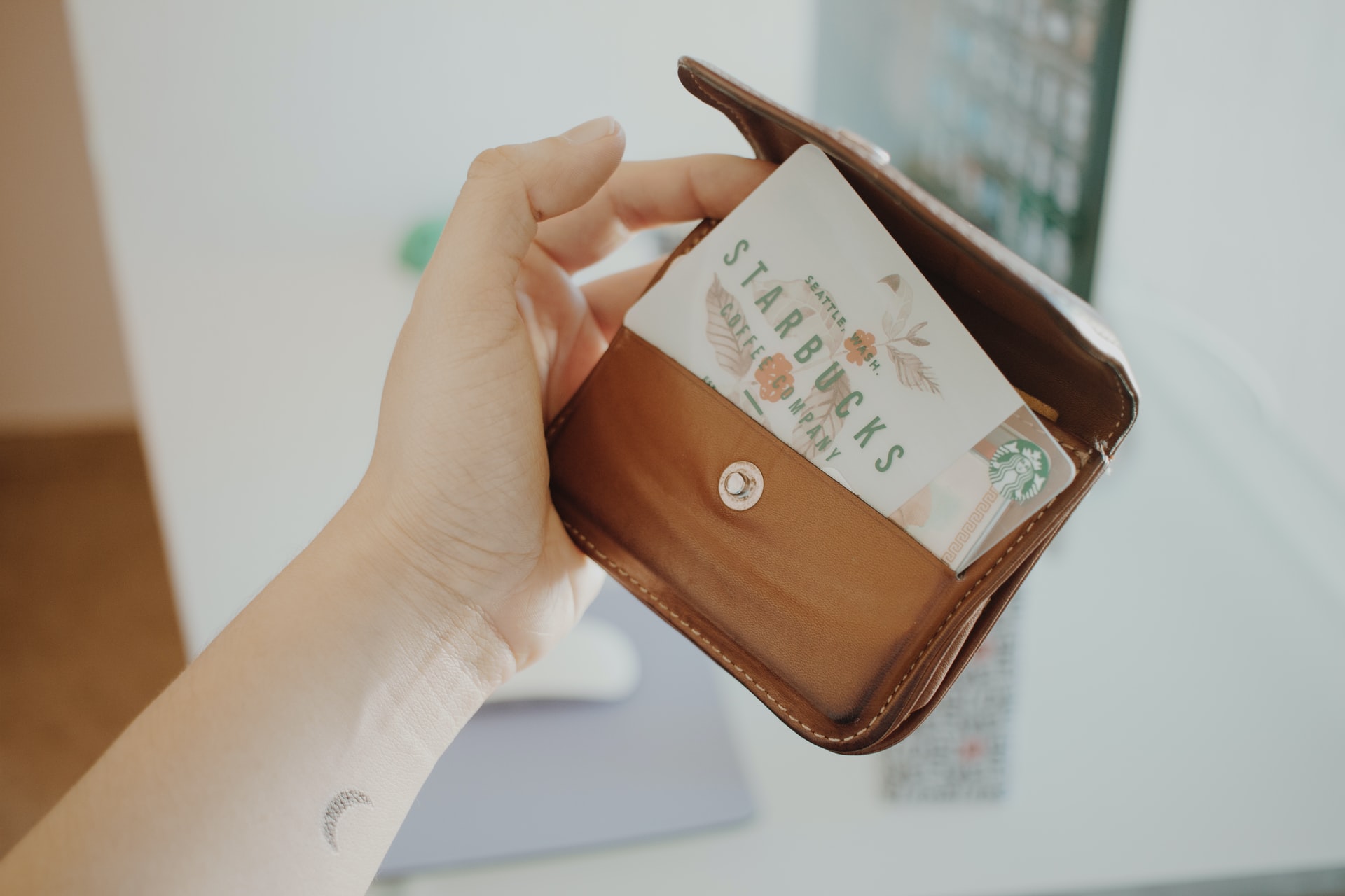 Person holding brown leather coin purse