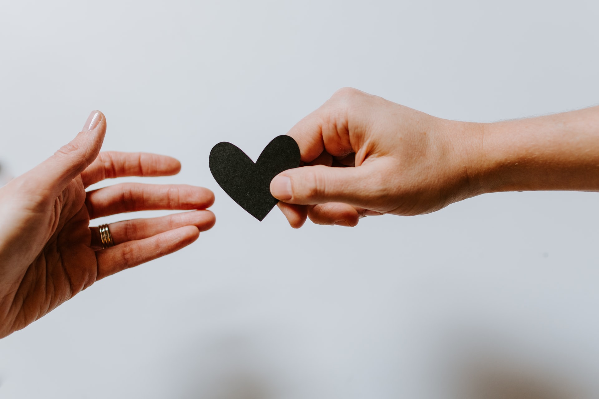 Person reaching for a heart of paper