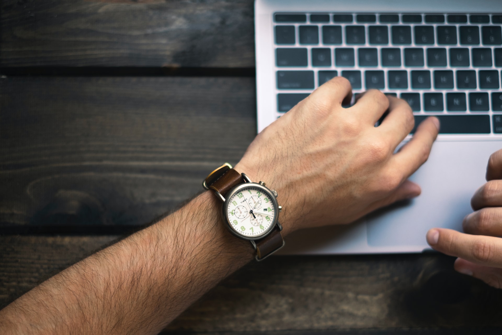 Person wearing a watch near laptop