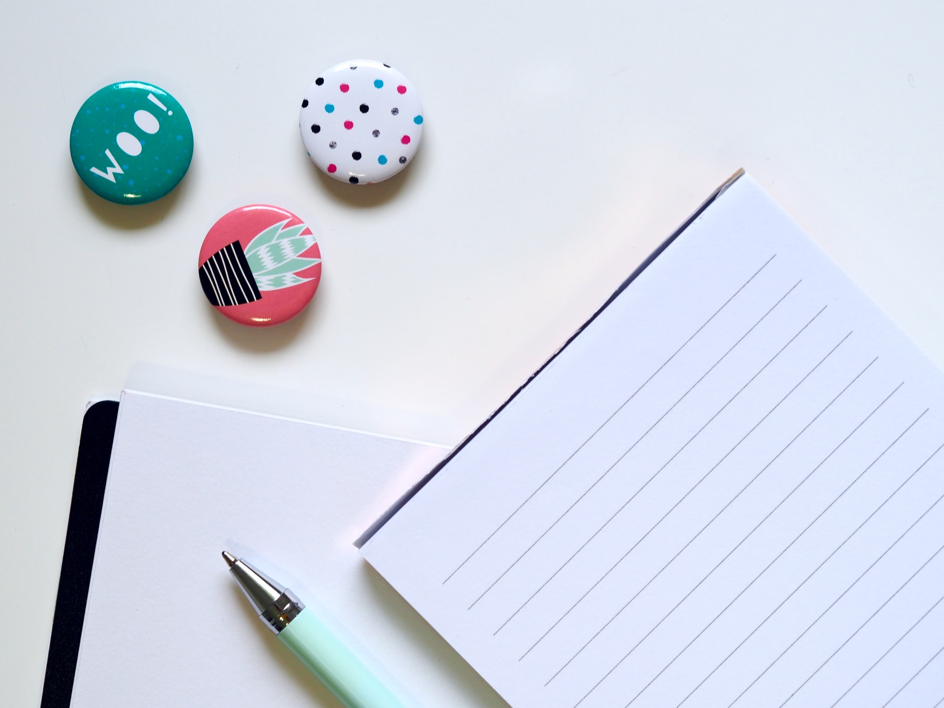 Three badges beside ruled paper