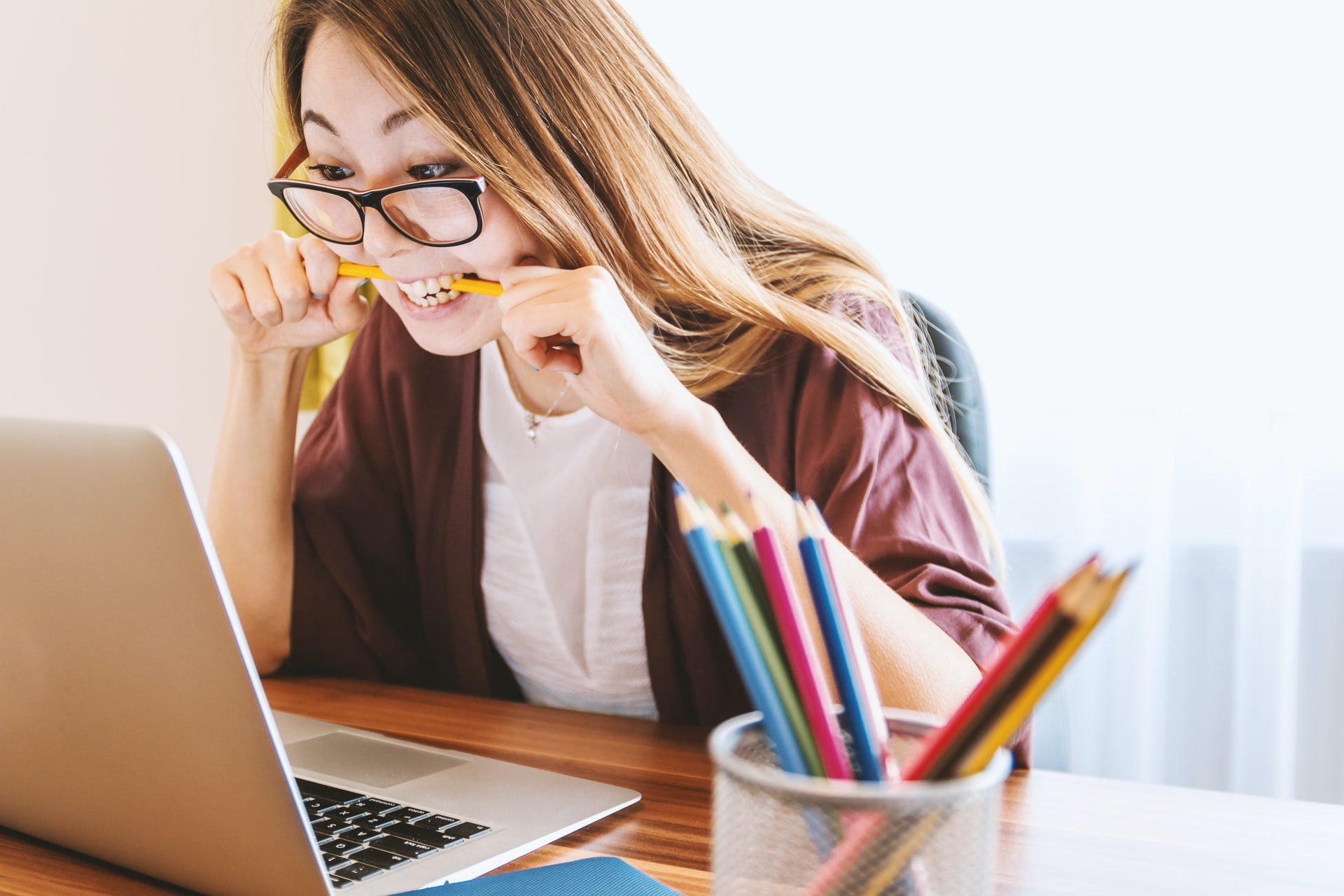 Woman bitting yellow pencil