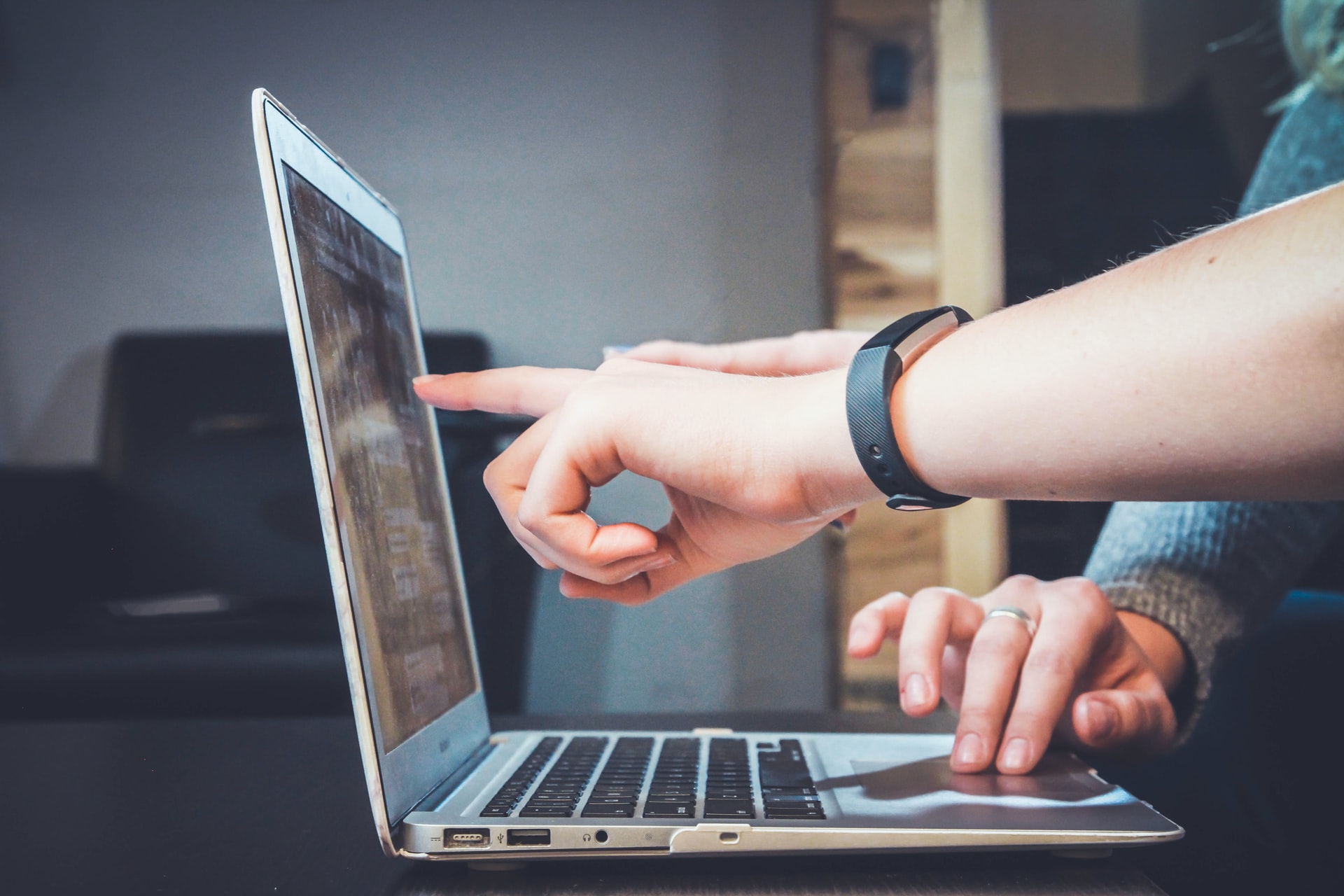 Two hands showing something on a laptop