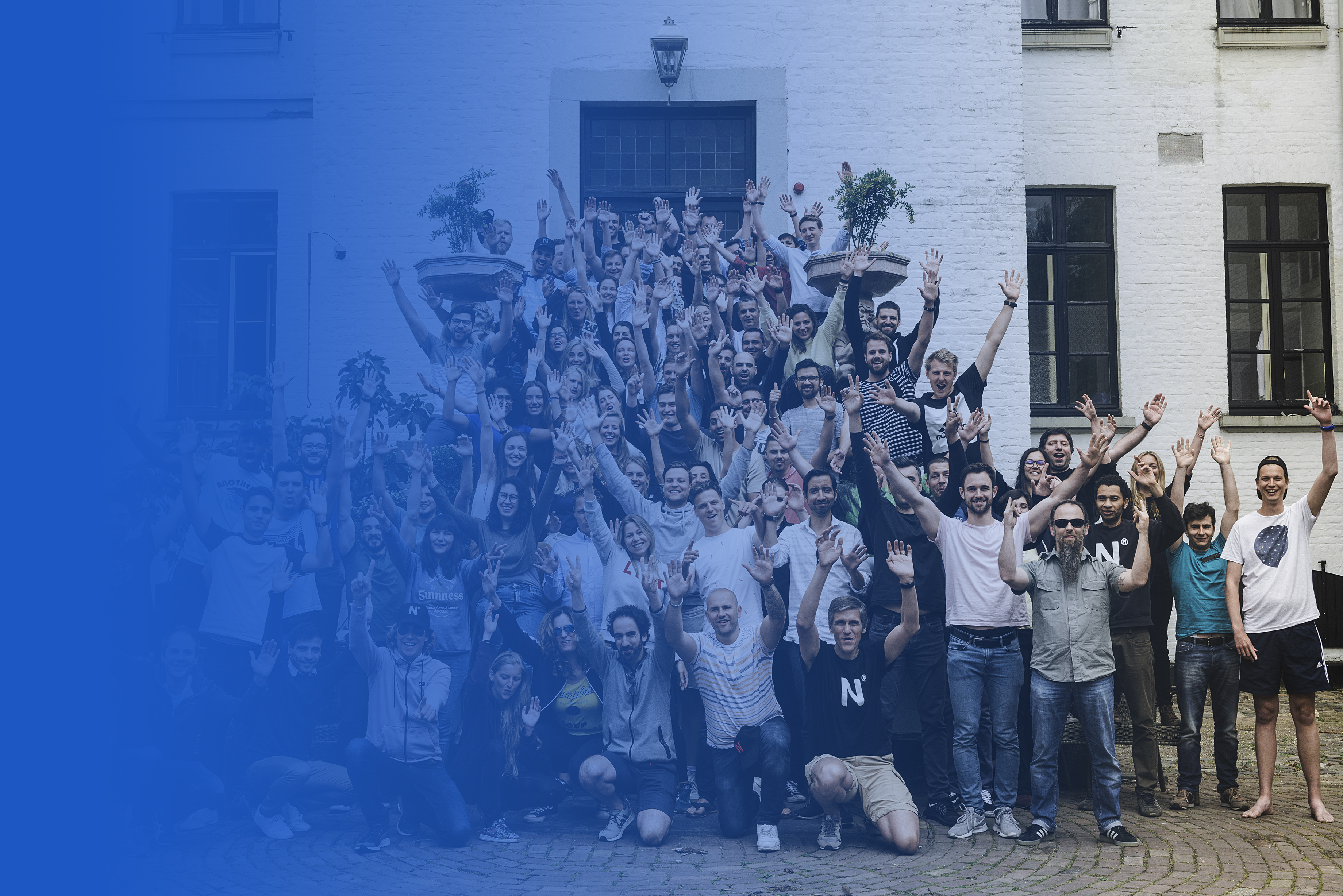 It's a team pictures with everyone who is part of Nmbrs. We are all raising our hands above our head and smiling.