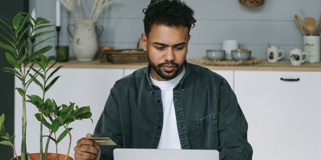 person-looking-at-computer-with-credit-card-in-hand