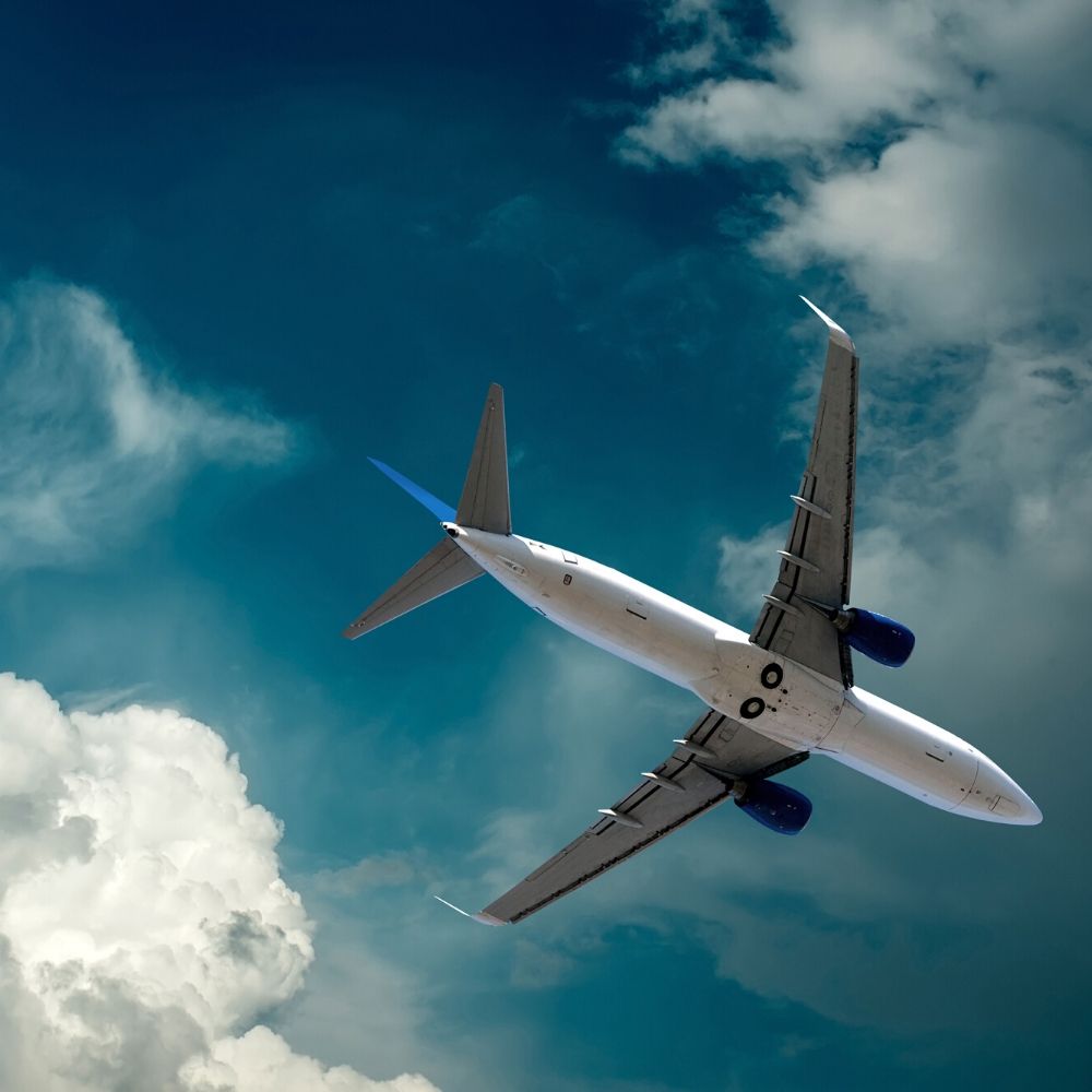 Airplane at flying under sky with clouds