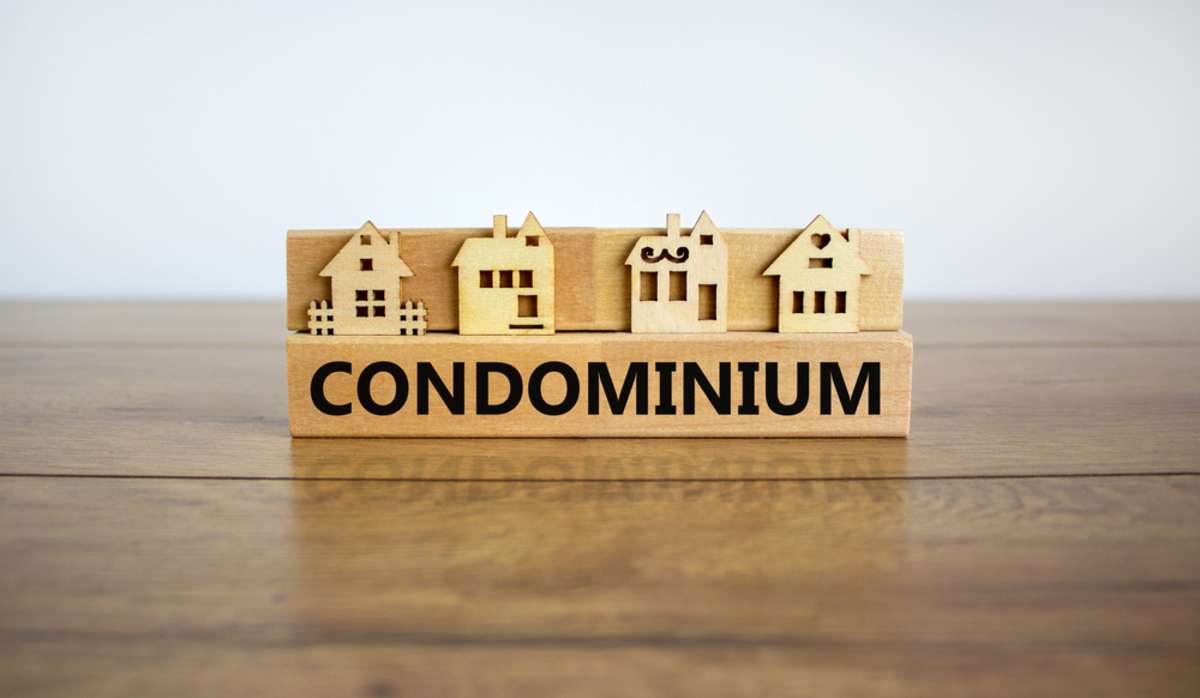 Block form the word condominium in front of a miniature house