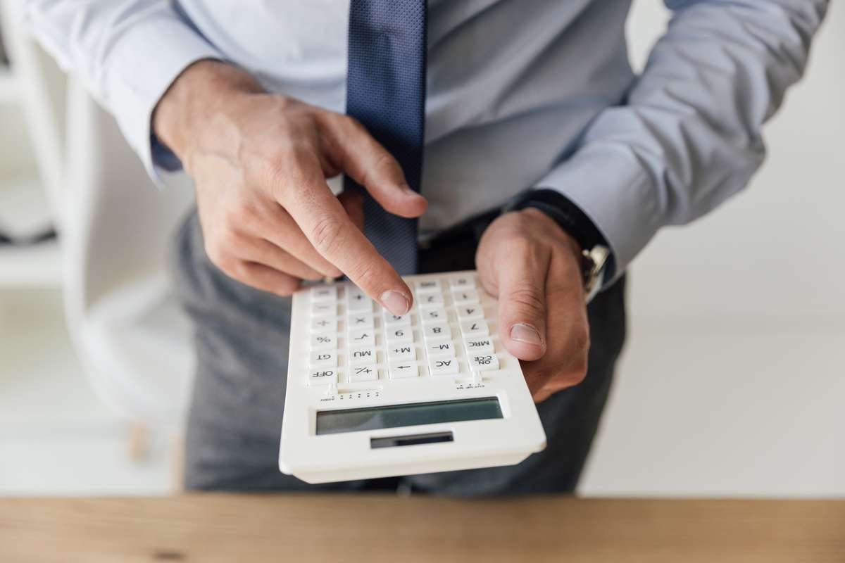 Businessman using calculator (R) (S)