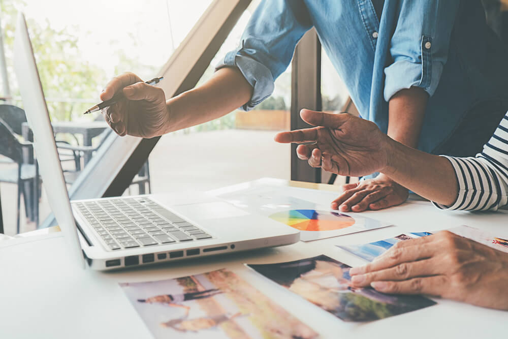 People discussing design options with a laptop | NameCorp