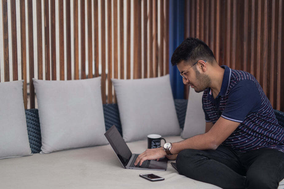 business person working from home on their couch with a coffee