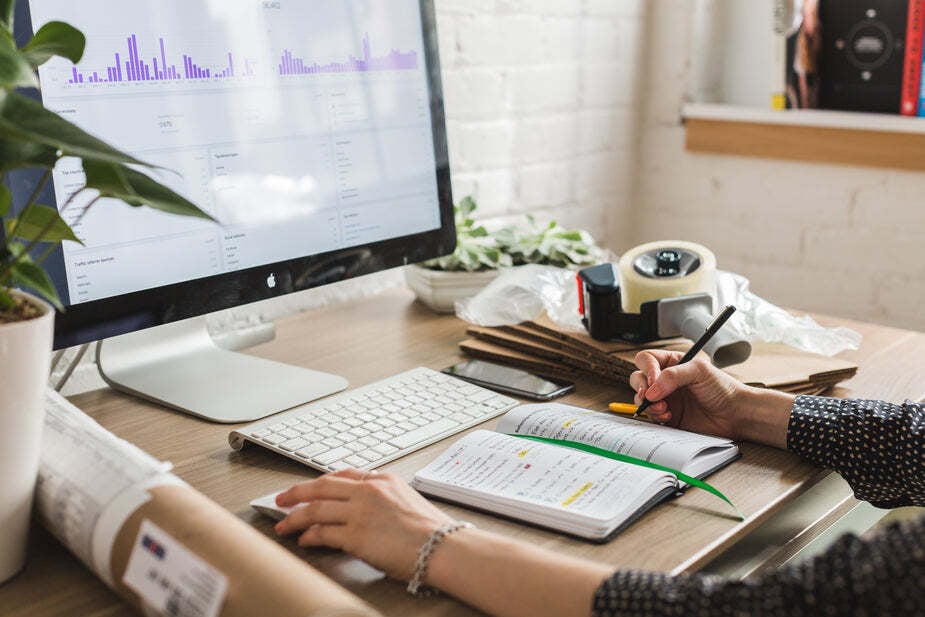 person looking at their computer with analytics and stats while they work