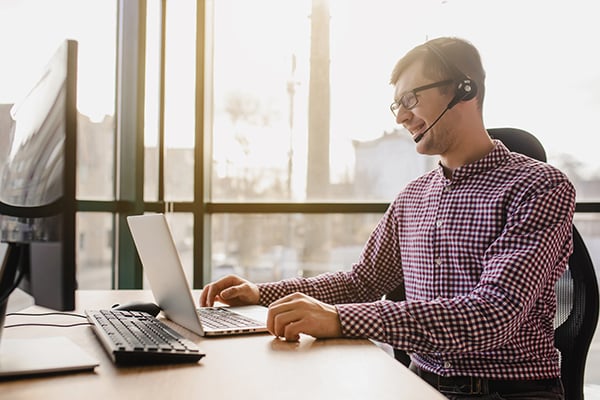 Man on phone call looking at laptop