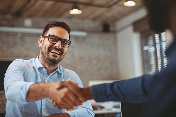Well dressed man shaking hands with another well dressed man
