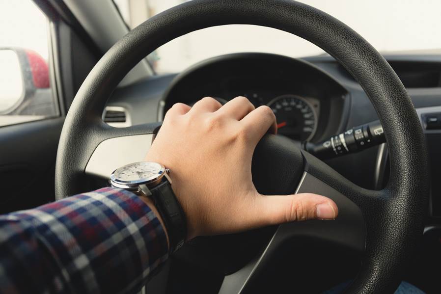 Persona que empuja el claxon mientras conduce sentado de un coche de prensa  de volante, sonido de bocina para advertir a otras personas en concepto de  tráfico.